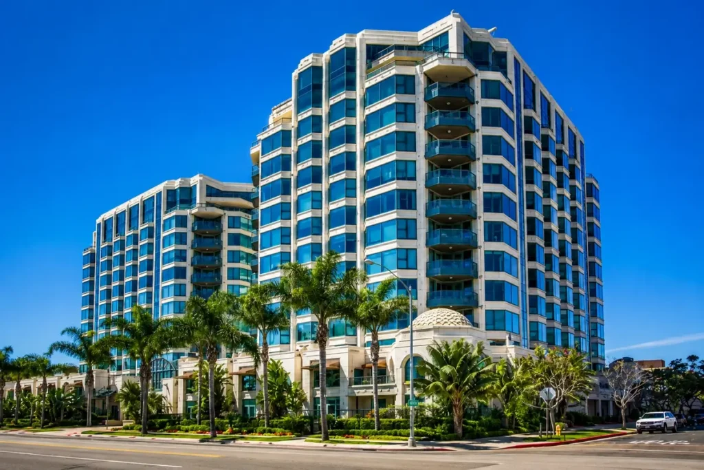 Curved glass mid-rise building lined with palm trees in San Diego, an example of commercial real estate eligible for hard money financing